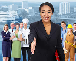 An instructional designer holding out her hand in friendly greeting with students from different industries behind her.